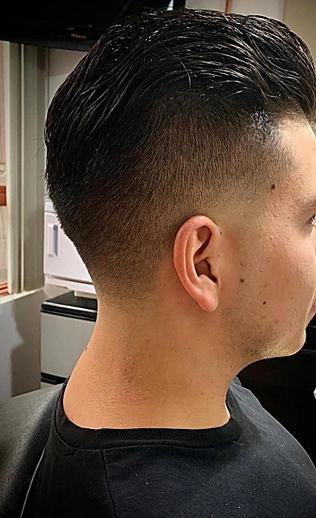 Corte con los lados rebajados al ras y el cabello largo arriba.